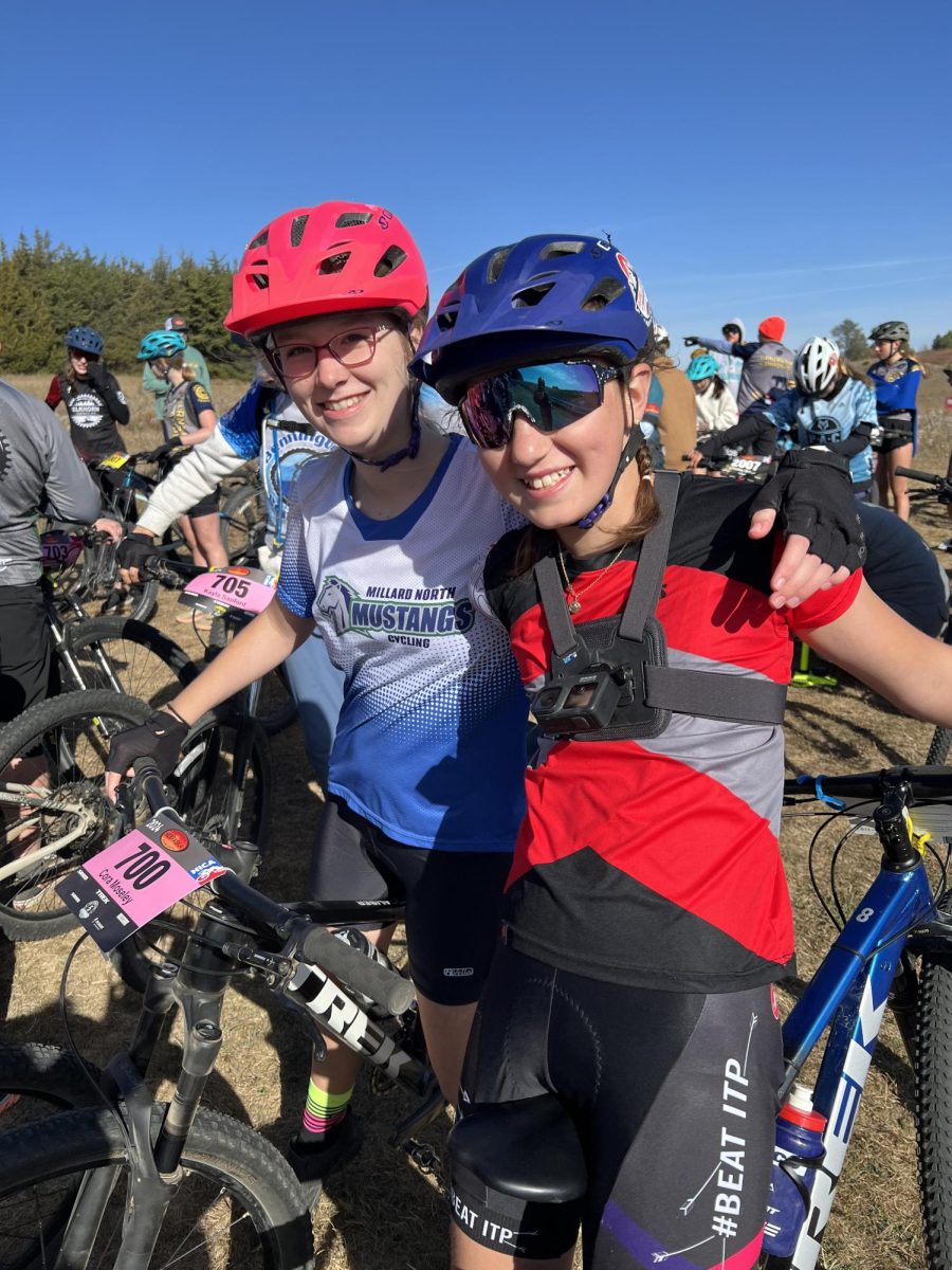 Cora Moseley wraps her arm around Emma Stromp's shoulder as they sit side-by-side on their bikes. The two friends have been biking around the neighborhood since childhood.