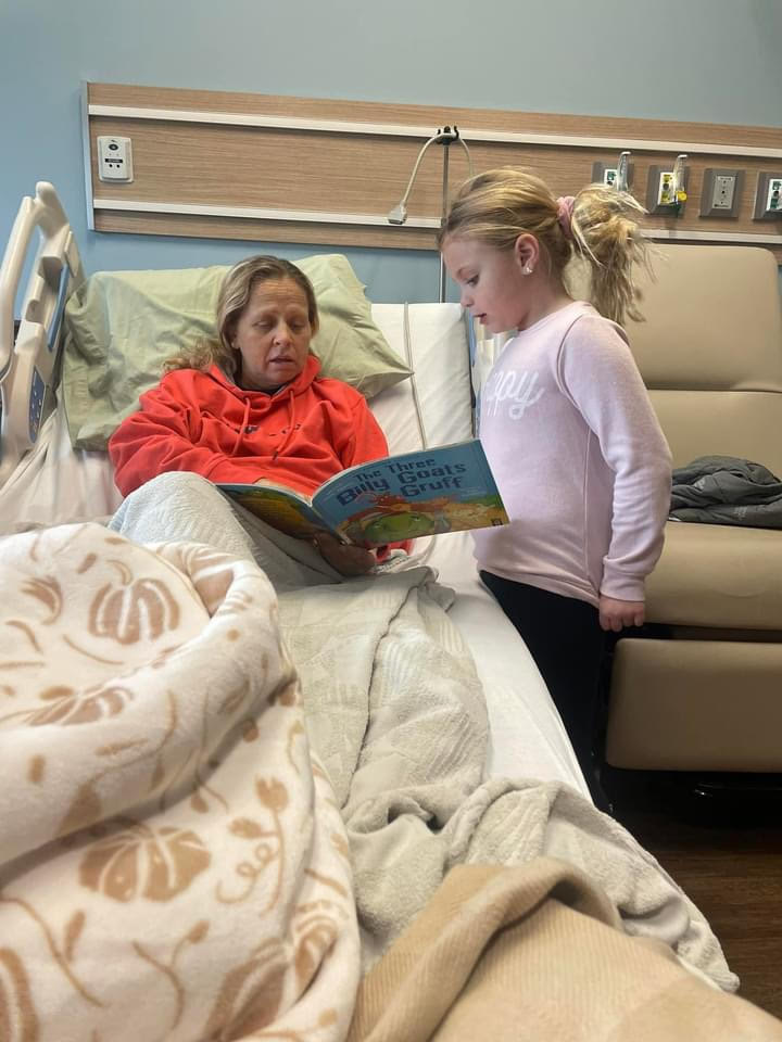 Alexa Kauffman, a first-grader, eagerly reads "The Three Billy Goats Gruff" aloud to her aunt Monica, who watches with a smile. Alexa has just learned the story and wanted to share it with her aunt.